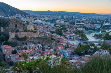 Georgia 'da Tiflis şehir merkezine bakan Narikala Kalesi' nin gün batımı manzarası
