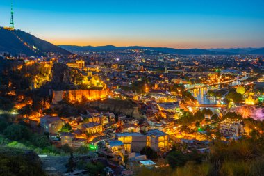 Georgia 'da Tiflis şehir merkezine bakan Narikala Kalesi' nin gün batımı manzarası