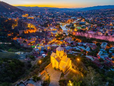 Georgia 'da Tiflis şehir merkezine bakan Narikala Kalesi' nin gün batımı manzarası