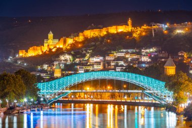 Gürcistan 'ın Tiflis kentindeki Narikala Kalesi ve Barış Köprüsü' nün gün batımı manzarası