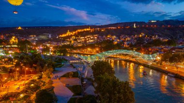 Gürcistan 'ın Tiflis kentindeki Narikala Kalesi ve Barış Köprüsü' nün gün batımı manzarası