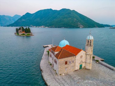 Karadağ 'ın Perast kenti yakınlarındaki Skrpjela Kilisesi ve Aziz George Katolik Manastırı' nın günbatımı manzarası