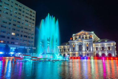 Romanya 'daki Drobeta-Turnu Severin' deki kinetik çeşme ve kültür sarayının gece görüşü