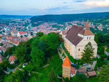 Romanya 'nın Sighisoara kentindeki tepedeki kilisenin gün batımı manzarası