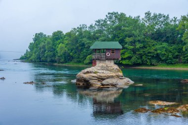 Wooden house on Drina river in Serbia clipart