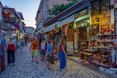 Mostar, Bosna-Hersek, 14 Temmuz 2023: Bosna-Hersek 'in eski Mostar kentinde bir turistik caddenin gün batımı manzarası