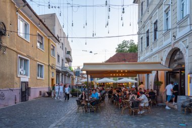 Cluj-Napoca, Romanya, 12 Ağustos 2023: Romanya 'nın Cluj-Napoca kentindeki bir caddenin gün batımı manzarası