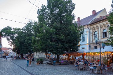 Cluj-Napoca, Romanya, 12 Ağustos 2023: Romanya 'nın Cluj-Napoca kentindeki bir caddenin gün batımı manzarası