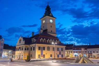 Brasov, Romanya, 15 Ağustos 2023: Romanya 'nın Brasov kentindeki Konsey Meydanı' ndaki belediye binasının gün doğumu manzarası