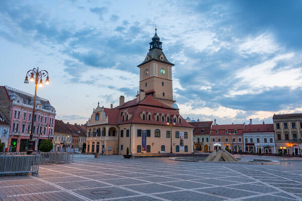 Brasov, Romania, August 15, 2023: Sunrise view of town hall at the The Council's Square in Brasov, Romania