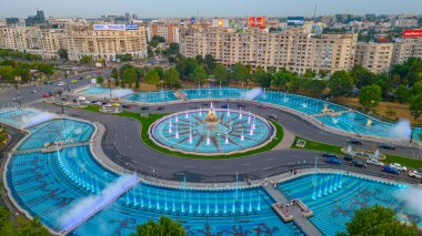 Bükreş, Romanya, 21 Ağustos 2023: Romanya 'nın Bükreş kentindeki Unirii meydanındaki bir çeşmenin günbatımı manzarası