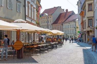 Ljubljana, Slovenya, 18 Haziran 2023: İnsanlar Ljubljana, Slovenya 'nın tarihi merkezinde bir sokakta geziniyorlar