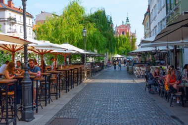 Ljubljana, Slovenya, 19 Haziran 2023: Ljubljana, Slovenya 'daki Ljubljanica nehrinin kıyısındaki restoran terası