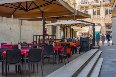 Trieste, İtalya, 21 Haziran 2023: İnsanlar İtalyan kenti Trieste 'nin merkezindeki tarihi bir sokakta geziniyorlar