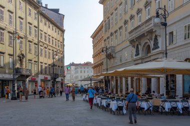Trieste, İtalya, 21 Haziran 2023: İnsanlar İtalyan kenti Trieste 'nin merkezindeki tarihi bir sokakta geziniyorlar
