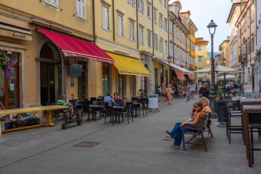 Trieste, İtalya, 21 Haziran 2023: İnsanlar İtalyan kenti Trieste 'nin merkezindeki tarihi bir sokakta geziniyorlar