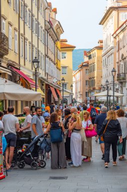 Trieste, İtalya, 21 Haziran 2023: İnsanlar İtalyan kenti Trieste 'nin merkezindeki tarihi bir sokakta geziniyorlar