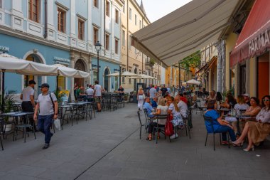 Trieste, İtalya, 21 Haziran 2023: İnsanlar İtalyan kenti Trieste 'nin merkezindeki tarihi bir sokakta geziniyorlar