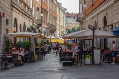 Trieste, İtalya, 21 Haziran 2023: İnsanlar İtalyan kenti Trieste 'nin merkezindeki tarihi bir sokakta geziniyorlar