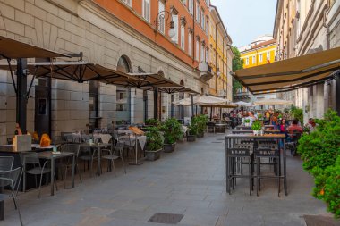 Trieste, İtalya, 21 Haziran 2023: İnsanlar İtalyan kenti Trieste 'nin merkezindeki tarihi bir sokakta geziniyorlar