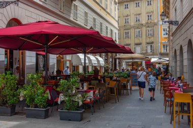 Trieste, İtalya, 22 Haziran 2023: İnsanlar İtalyan kenti Trieste 'nin merkezindeki tarihi bir sokakta geziniyorlar