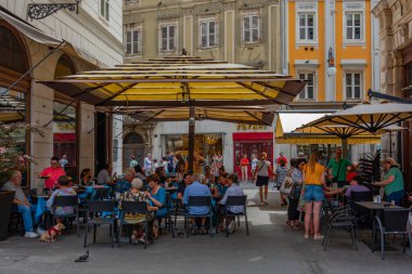 Trieste, İtalya, 22 Haziran 2023: İnsanlar İtalyan kenti Trieste 'nin merkezindeki tarihi bir sokakta geziniyorlar