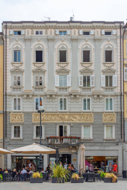 Trieste, İtalya, 22 Haziran 2023: İnsanlar İtalyan kenti Trieste 'nin merkezindeki tarihi bir sokakta geziniyorlar