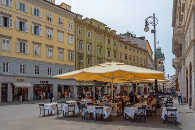 Trieste, İtalya, 22 Haziran 2023: İnsanlar İtalyan kenti Trieste 'nin merkezindeki tarihi bir sokakta geziniyorlar
