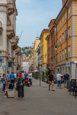 Trieste, İtalya, 22 Haziran 2023: İnsanlar İtalyan kenti Trieste 'nin merkezindeki tarihi bir sokakta geziniyorlar