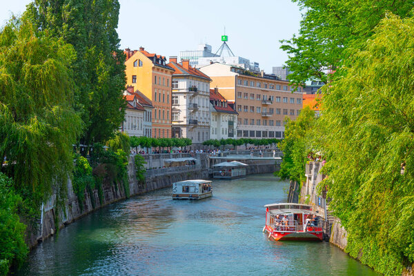 Ljubljana, Slovenia, June 18, 2023: Tourist boats cruising Ljubljanica river in the Slovenian capital Ljubljana