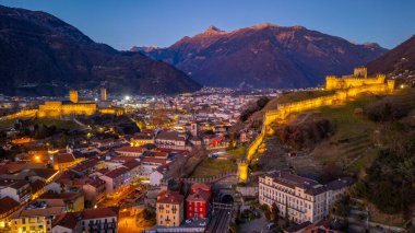 Castelgrande ve Castello di Montebello ile Bellinzona 'nın gün batımı manzarası.
