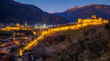 Castelgrande ve Castello di Montebello ile Bellinzona 'nın gün batımı manzarası.
