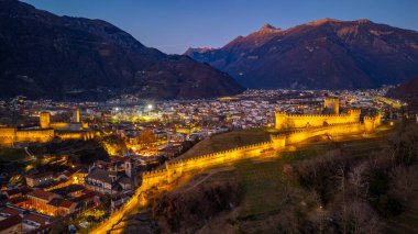 Castelgrande ve Castello di Montebello ile Bellinzona 'nın gün batımı manzarası.