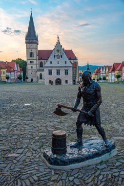 Bardejov, Slovakya 'daki ana meydanın gün batımı manzarası ve celladın heykeli.