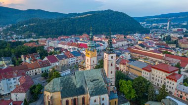 Şehir Kalesi 'nin gün batımı manzarası ve Banska Bystrica, Slovakya' daki Bakire Meryem 'in Varsayımı Kilisesi.