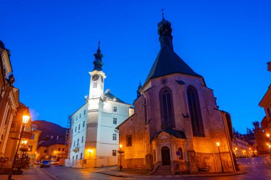 Banska Stiavnica, Slovakya 'daki belediye binasının ve Saint Catherine kilisesinin gece manzarası.