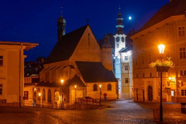 Banska Stiavnica, Slovakya 'daki belediye binasının ve Saint Catherine kilisesinin gece manzarası.