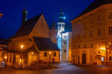 Banska Stiavnica, Slovakya 'daki belediye binasının ve Saint Catherine kilisesinin gece manzarası.