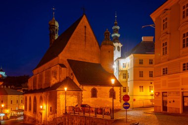 Banska Stiavnica, Slovakya 'daki belediye binasının ve Saint Catherine kilisesinin gece manzarası.