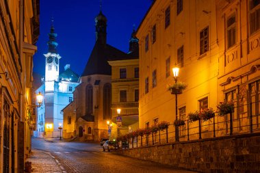 Banska Stiavnica, Slovakya 'daki belediye binasının ve Saint Catherine kilisesinin gece manzarası.