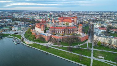 Wawel Kalesi 'nin Polonya şehri Krakow / Krakow' daki günbatımı görüntüsü Vistula / Wisla nehrine yansıdı.