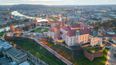 Wawel Kalesi 'nin Polonya şehri Krakow / Krakow' daki günbatımı görüntüsü Vistula / Wisla nehrine yansıdı.