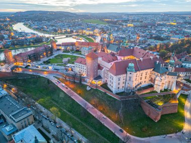 Wawel Kalesi 'nin Polonya şehri Krakow / Krakow' daki günbatımı görüntüsü Vistula / Wisla nehrine yansıdı.