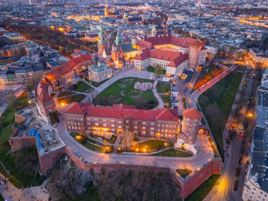 Wawel Kalesi 'nin Polonya şehri Krakow / Krakow' daki günbatımı görüntüsü Vistula / Wisla nehrine yansıdı.