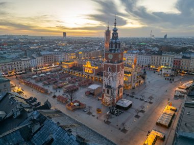 Saint Mary kilisesi ve Cracow / Krakow 'da güzel bir pazar yeri olan Rynek parlayan ana meydanının gün doğumu manzarası...