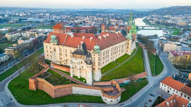Wawel Kalesi 'nin Polonya şehri Krakow / Krakow' daki günbatımı görüntüsü Vistula / Wisla nehrine yansıdı.