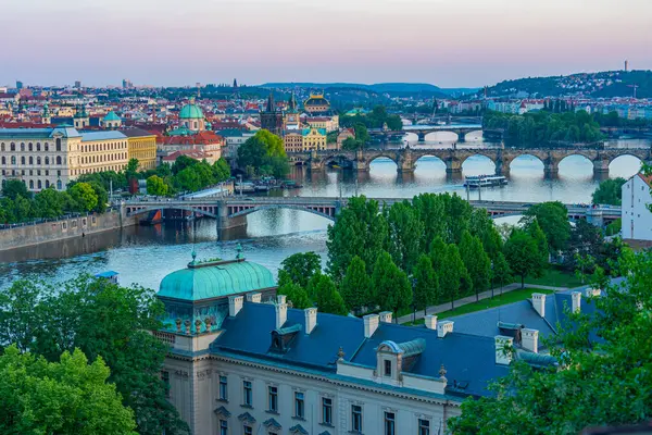 Vltava Nehri üzerinde gün batımı Çek Cumhuriyeti, Prag 'da Letna' dan Straka Akademisi 'nin arkasında görülüyor.