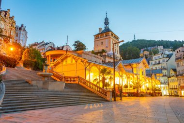 Çek Cumhuriyeti 'nin Karlovy Vary kentindeki saray kulesi ve pazar sütununun günbatımı.