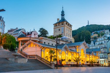 Çek Cumhuriyeti 'nin Karlovy Vary kentindeki saray kulesi ve pazar sütununun günbatımı.