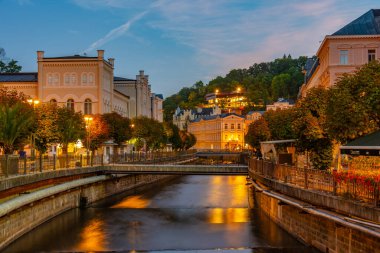 Çek Cumhuriyeti 'nin Karlovy Vary kentindeki Tepla Nehri' ne yansıyan renkli evlerin gece görüşü.